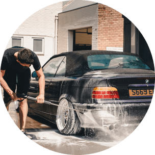 Barbat spala un BMW negru